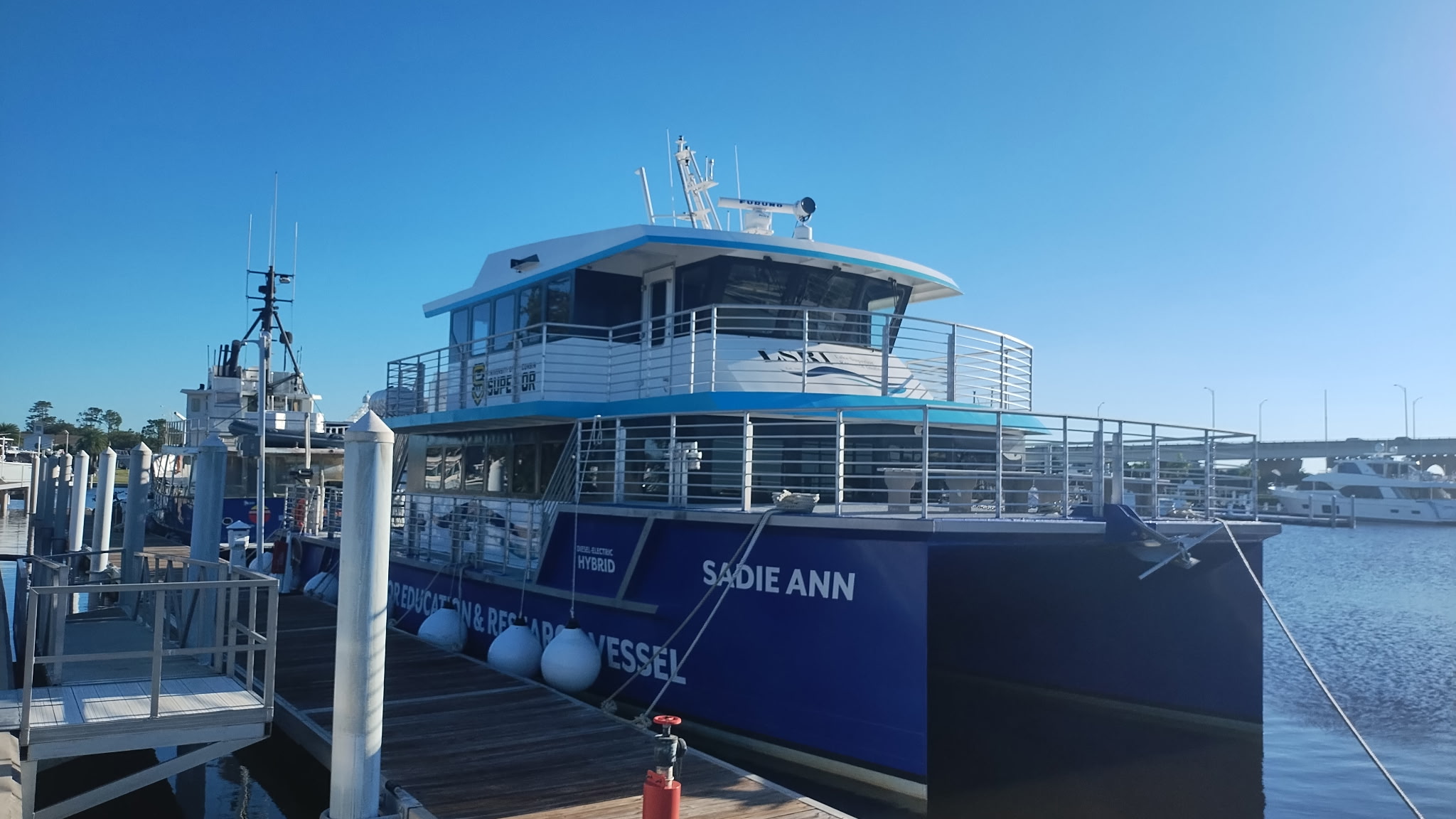 The blue and white UW–Superior research vessel Sadie Ann docked at a pier.