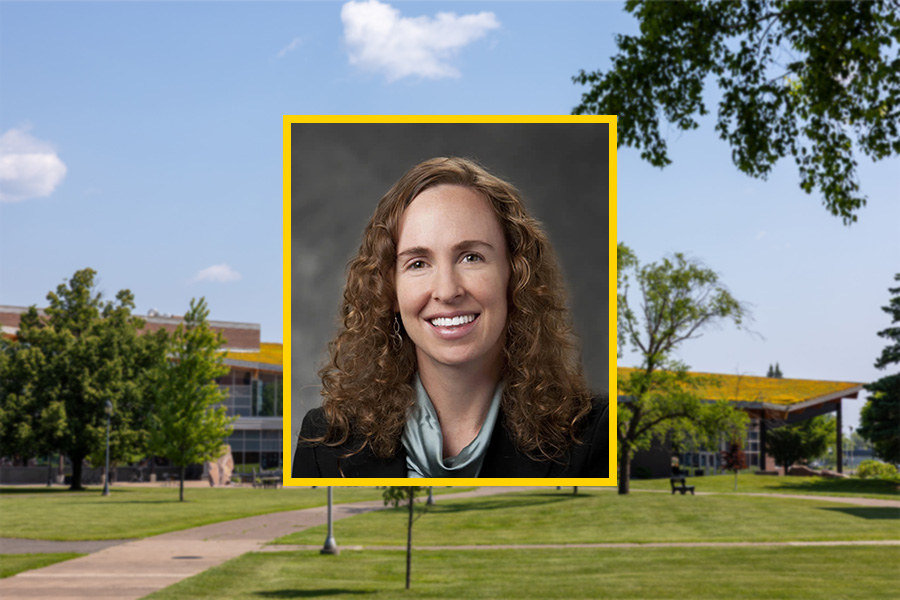 A woman with wavy hair smiles in a portrait overlaid on a college campus background.