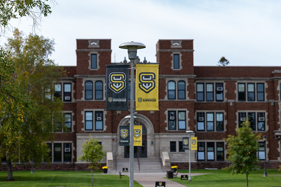 University of Wisconsin-Superior banners in front of a brick campus building.