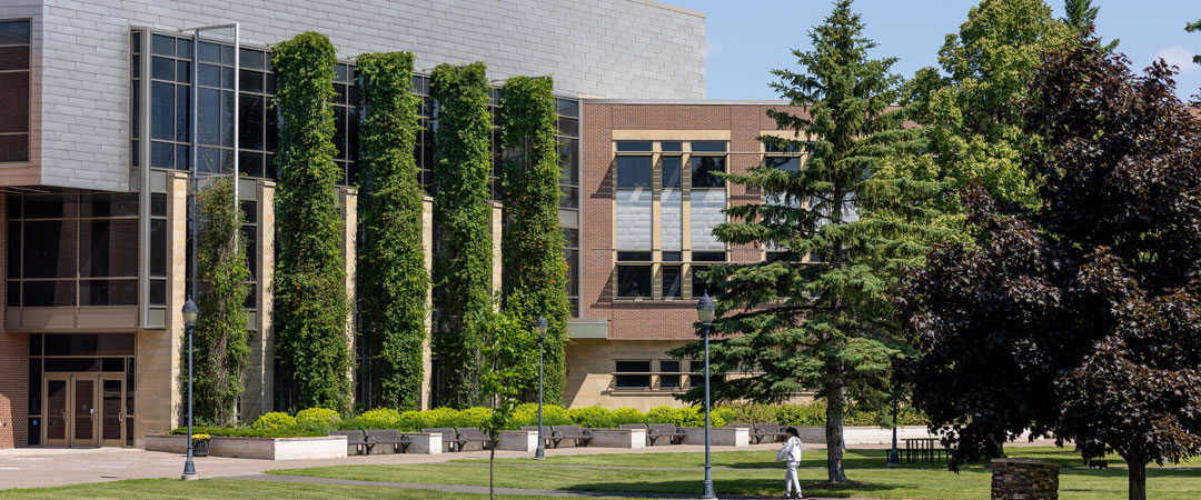 Swenson hall exterior, a modern building with vines growing up the front window area.