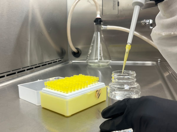A gloved hand uses a pipette aboard the Sadie Ann research vessel on Lake Superior.