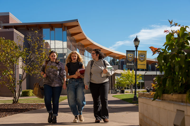 Three students walk together on a UW-Superior campus path.