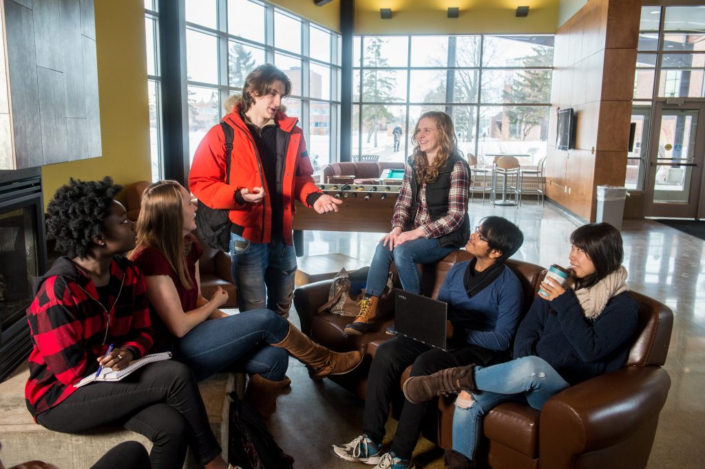 UW-Superior students gathered around the Yellowjacket Union fireplace having a discussion